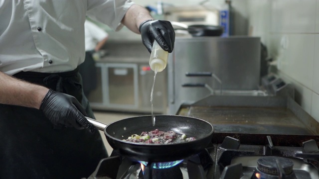 厨师在厨房用煎锅做饭视频素材