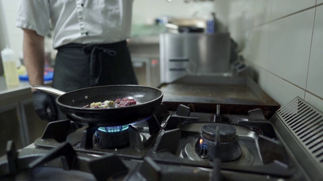 厨师在厨房用煎锅做饭视频素材