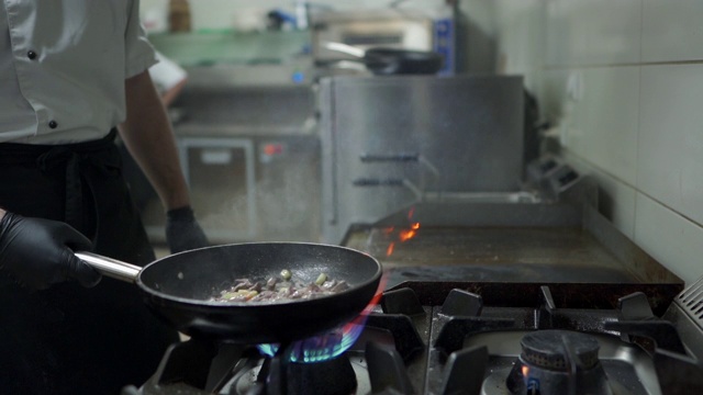 厨师在厨房用煎锅做饭视频素材