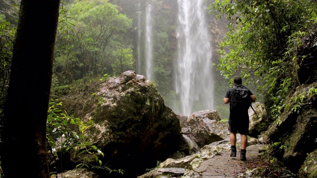 徒步旅行者在澳大利亚热带雨林欣赏瀑布视频素材