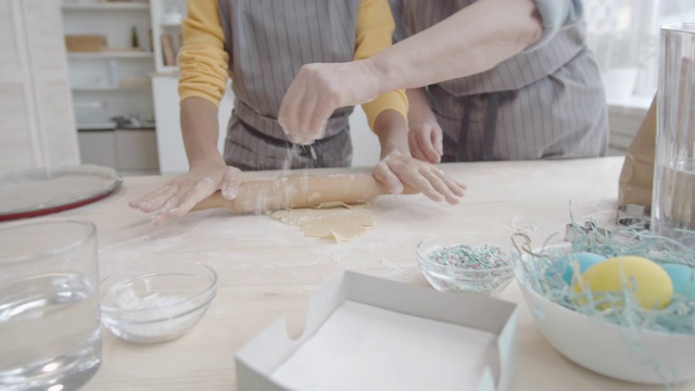 在奶奶的帮助下，小女孩正在擀饼干面团视频素材