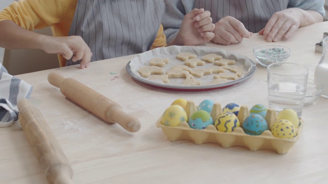 老女人和她的小孙女一起做复活节饼干视频素材