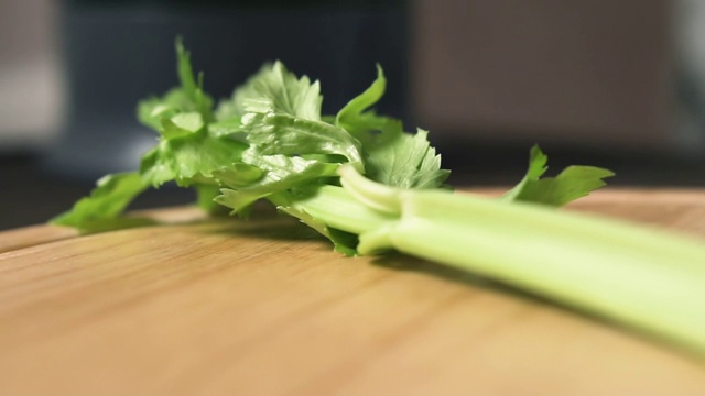 女性用刀切芹菜茎，动作缓慢。健康食品的概念。视频素材