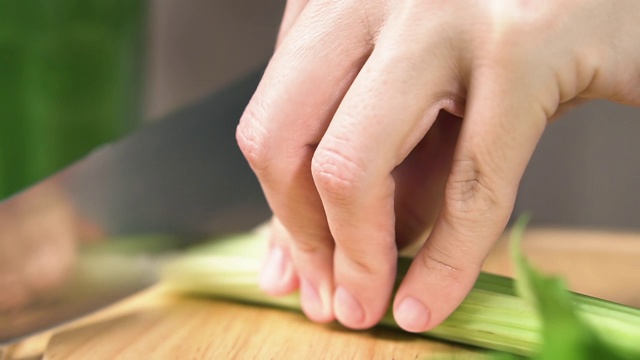 女性用刀切芹菜茎，动作缓慢。健康食品的概念。视频素材