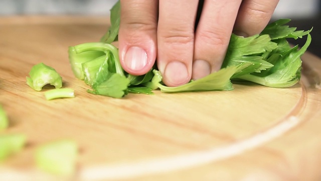 女性用刀切芹菜茎，动作缓慢。健康食品的概念。视频素材