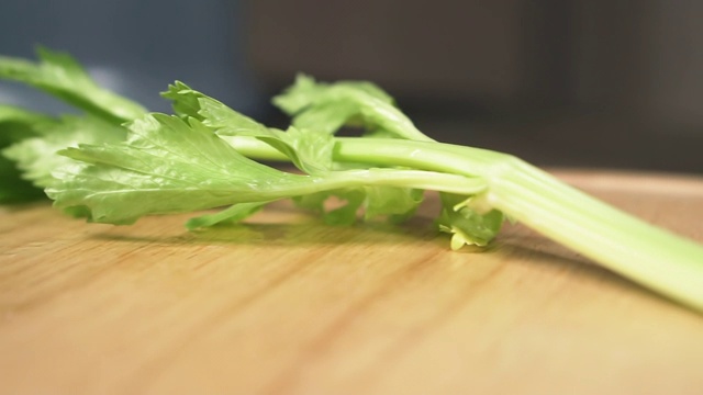 女性用刀切芹菜茎，动作缓慢。健康食品的概念。视频素材