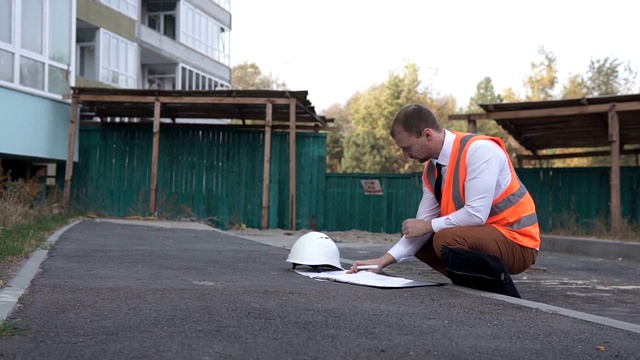 一个建筑工地上的年轻工头正在看图纸。建筑新技术的概念。视频素材