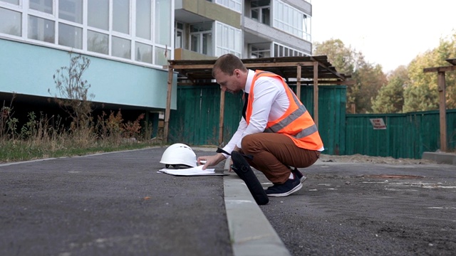 一个建筑工地上的年轻工头正在看图纸。建筑新技术的概念。视频素材