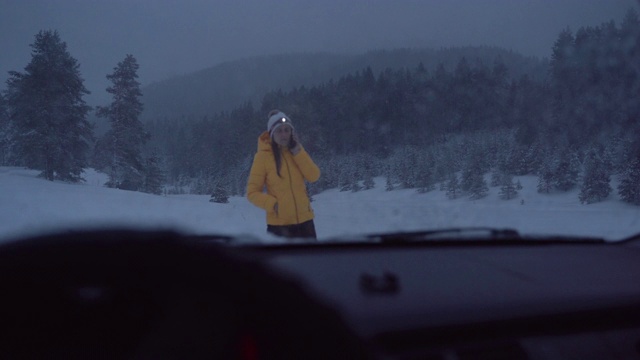 汽车观点。在雪地里开车。汽车在路上抛锚了。在恶劣的天气下，汽车会在偏僻的地方抛锚。汽车保险。一个女人在路上。视频素材