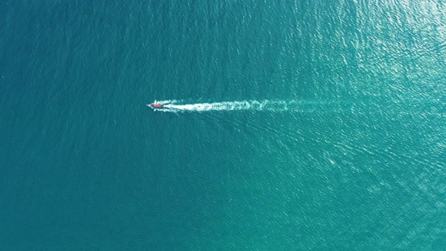 鸟瞰图上的长尾船漂浮在清澈的水沿沙滩在泰国。夏季鸟瞰图镜头4K。视频素材