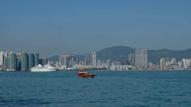 以城市天际线为背景的香港海岸附近的船只和渡轮视频素材