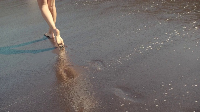 沙滩上女人的腿。女孩走在海边的沙滩上视频素材