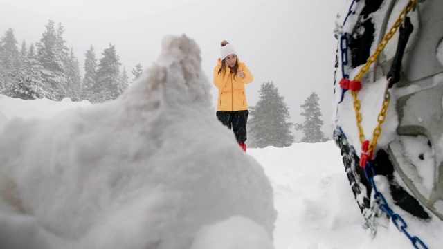 汽车观点。在雪地里开车。汽车在路上抛锚了。在恶劣的天气下，汽车会在偏僻的地方抛锚。汽车保险。一个女人在路上。视频素材