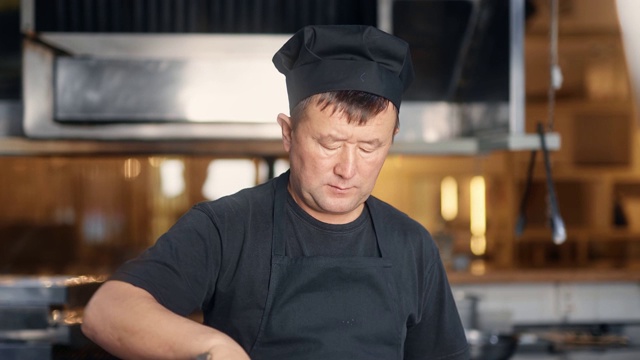 亚洲厨师在炉子上用平底锅烹饪混合食物的肖像。中近距离拍摄4k红色相机视频素材