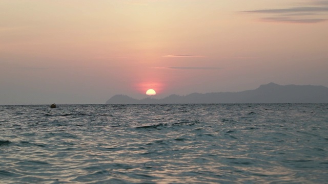 红色日落在海上视频4K。太阳落到地平线上。红色的天空，黄色的太阳和惊人的海洋。夏日夕阳海景。泰国格兰塔海滩视频素材