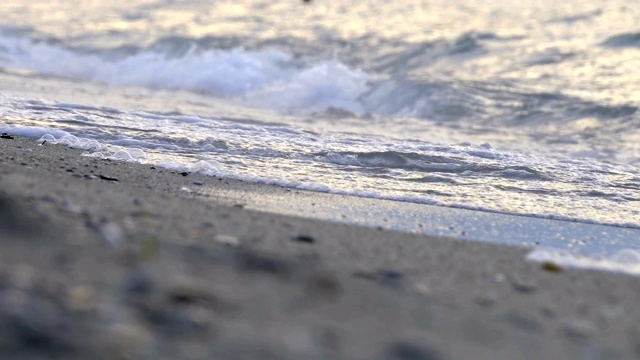 柔软的海浪和泡沫在海滩上，电影的深度视频素材