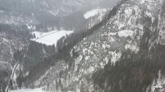 无人机在冬天飞向一座有森林和积雪的山脊视频素材