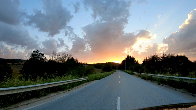 在夕阳西下的乡间小路上开车视频素材