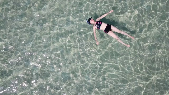 女人漂浮在清澈的大海里视频素材