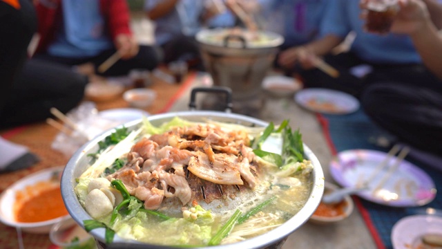 在平底锅上烤猪肉，在热锅上合上肉片，蔬菜在热汤，辛辣美味的烹饪党人，模糊的菜和盘子在地上，模糊筷子手，食物概念俯视图视频素材