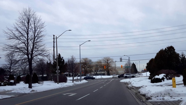 在城市灯光十字路口，汽车在繁忙的街道上行驶。在城市道路上行驶的车辆与移动的交通和雪。视频素材