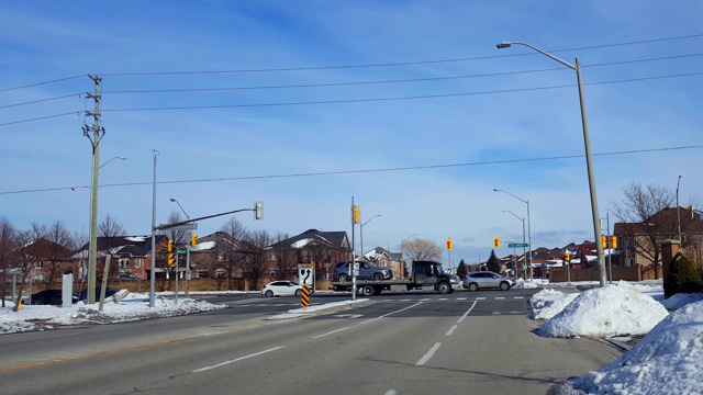 在城市灯光十字路口，汽车在繁忙的街道上行驶。在城市道路上行驶的车辆与移动的交通和雪。视频素材