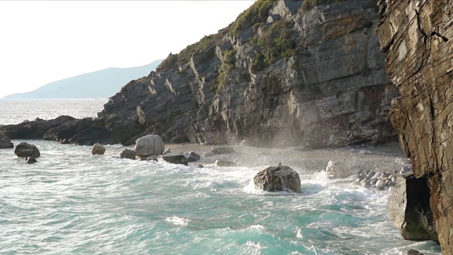 在岩石海岸上冲浪和浪花。慢动作视频素材