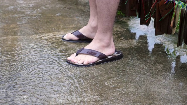 男足与凉鞋，而雨在慢动作视频素材