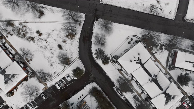 冬天，被雪覆盖的小镇上空，一架无人机在郊区附近低空飞行视频素材