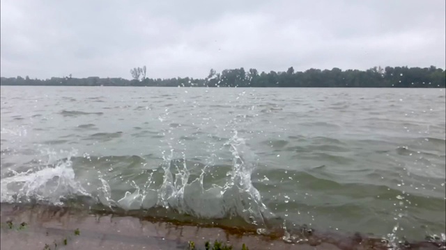 在多瑙河河岸，缓慢的河水冲击着被洪水淹没的人行道视频素材