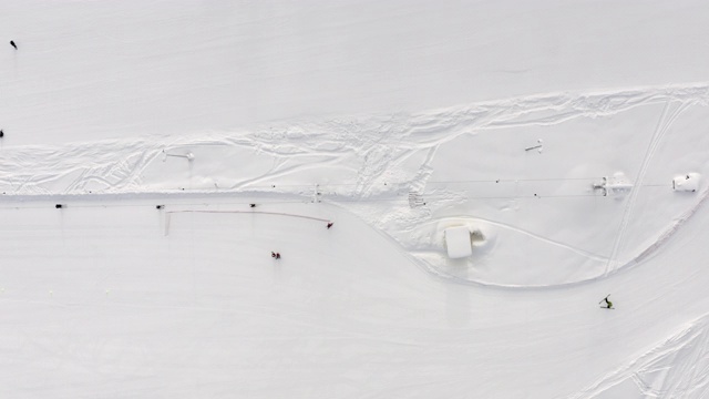 顶部鸟瞰图滑雪升降机运输滑雪者和滑雪板。无人机广角观看人们在雪山滑雪场滑雪和滑雪板。滑雪电梯在雪坡的绳索道上视频素材