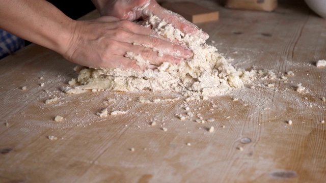 用全麦面粉制作自制素食意面。厨师把面粉倒在土豆泥上，这是传统的意大利面食，女人在厨房里做饭视频素材