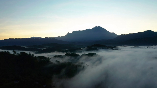 在婆罗洲沙巴州，以基纳巴卢山为背景的云雾雨林的4k镜头美丽的日出视频素材