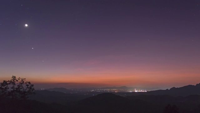 延时4k视频。泰国南邦梅莫，在迷雾笼罩的夜空中，长时间曝光的山上，星星排列(土星、月亮、金星、木星)的现象。视频素材