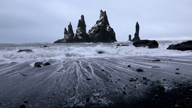 玄武岩岩石巨魔脚趾在黑海滩风暴。Reynisdrangar、湾、冰岛。视频素材