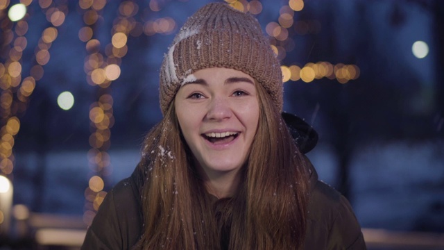 正面的年轻白人女孩的肖像在户外的脸上雪球。漂亮的黑发女人，灰色眼睛和朋友玩雪球。冬天好玩，休闲游戏，打雪仗。视频素材