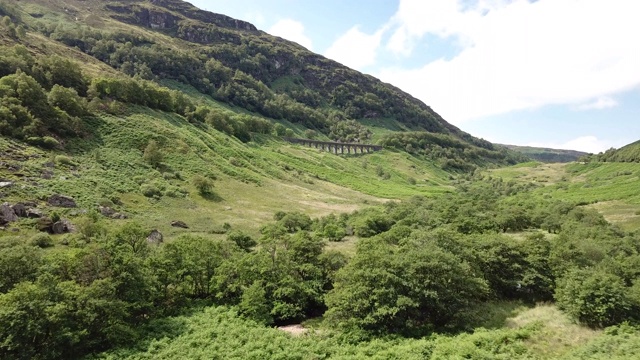 空中飞行穿过苏格兰山谷朝向高架桥视频素材