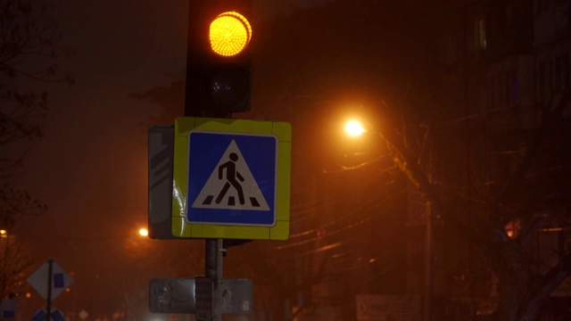 夜市街景，行人交叉警告标志，交通灯闪烁。视频素材