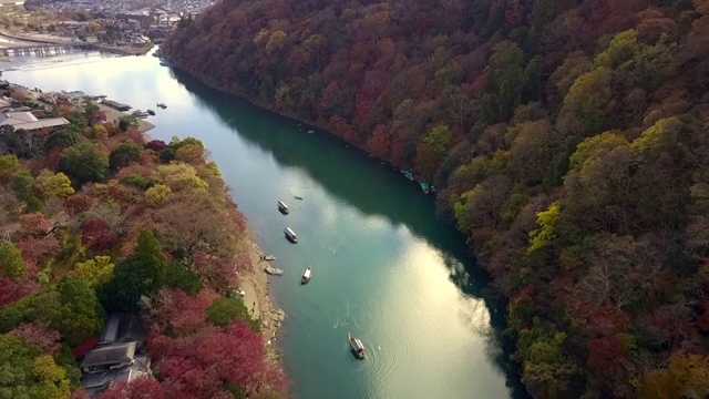 鸟瞰图多彩的岚山河与旅游船在水和森林在秋天的颜色，桂河在秋天和船，岚山，京都，日本。视频素材