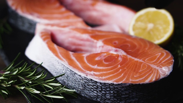 厨师用慢动作将鲑鱼排涂在厨房板上烹饪。健康食品的概念。视频素材