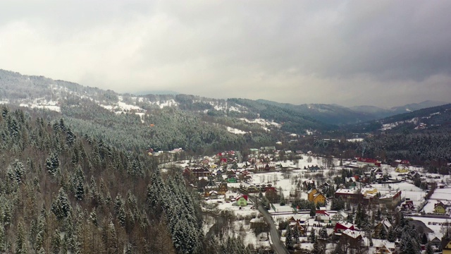 森林被雪覆盖的鸟瞰图。山村鸟瞰图视频素材