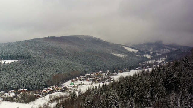 森林被雪覆盖的鸟瞰图。山村鸟瞰图视频素材