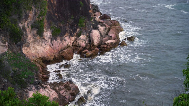 一个高角度的海岸，看起来像一个悬崖与海浪冲击海岸，看起来可怕。视频素材