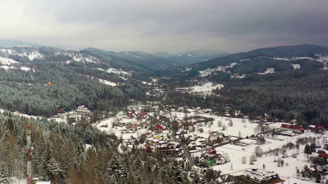 森林被雪覆盖的鸟瞰图。山村鸟瞰图视频素材