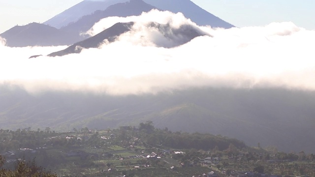 在黎明的云层中看到三座巴厘岛火山。阿贡，巴图尔和阿邦视频素材