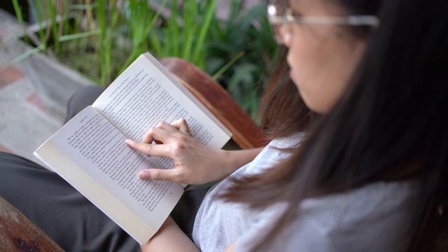 在后院看书的女人的侧视图视频素材