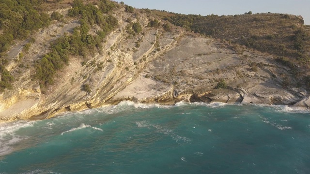 鸟瞰图的小海滩与绿松石水旁边的岩石和树木在Agia Paraskevi Halkidiki地区，希腊。从无人机视频素材