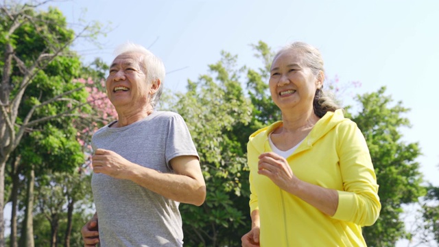 一对亚洲老夫妇在公园里慢跑视频素材