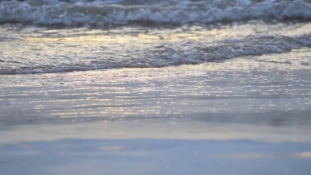 夏天日落时海滩上的海浪。视频素材