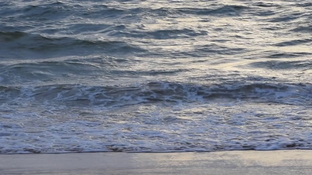 夏天日落时海滩上的海浪。视频素材